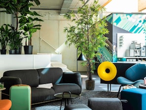 Un espace de vie moderne comprenant un canapé, une machine à café et un escalier.