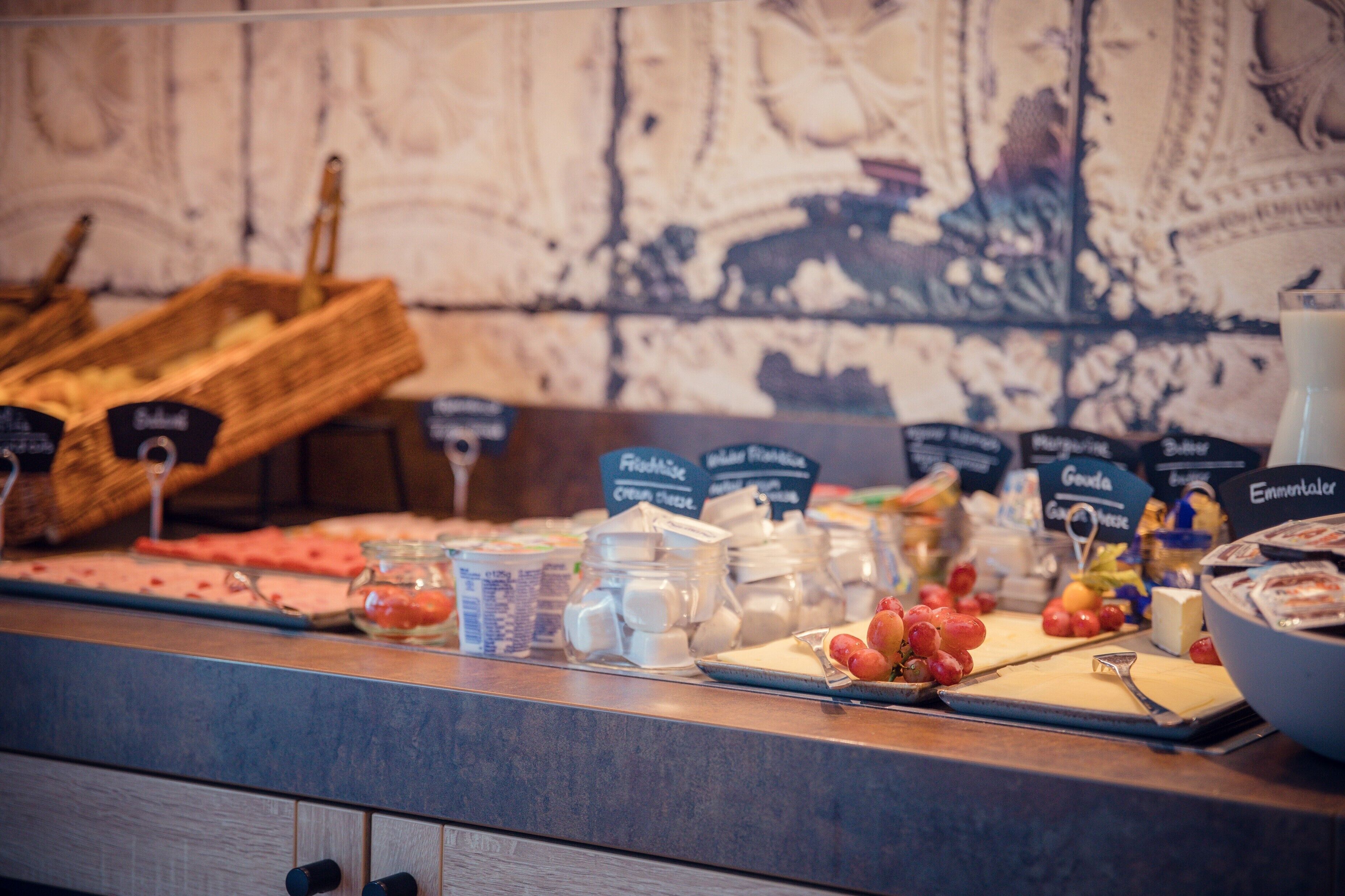 A buffet counter with various food items and condiments.