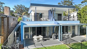 A modern two-story house with a balcony, large windows, and a deck area. - Orion Blue Beach Stay, Vincentia (Vincentia)