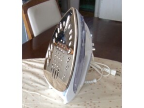 An iron is conveniently located on a table with a tablecloth.
