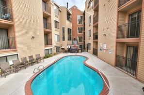 A swimming pool surrounded by a courtyard with a brick border, outdoor seating, and a barbecue area. - Carriage House 1BR | Ski Slope Views | Fireplace | Pool & Hot Tub (Park City)