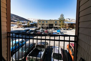 A view of a parking lot with various vehicles and a building in the background. - Carriage House 1BR | Ski Slope Views | Fireplace | Pool & Hot Tub (Park City)
