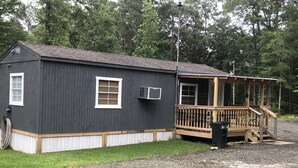 Un petit bâtiment d’un seul étage, doté d’une terrasse en bois et d’un porche couvert.