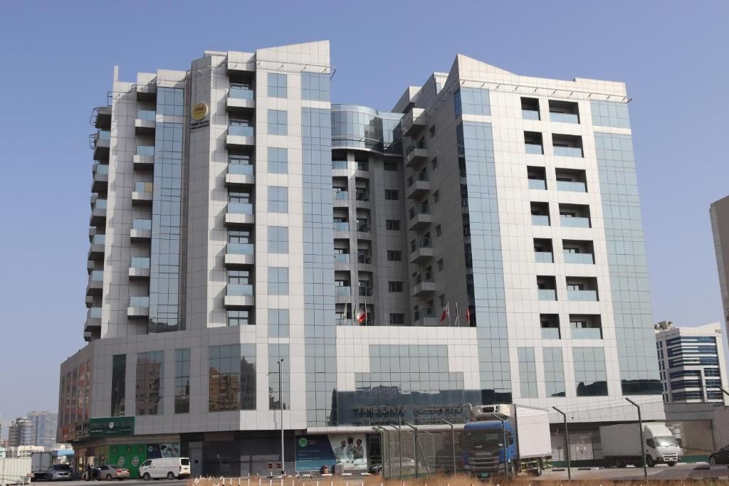 A multi-story hotel with a modern design, featuring a prominent glass facade and a series of balconies.