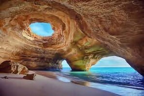 A natural rock formation with a circular opening and a view of the ocean. - Senhora da Rocha Apartment w/ SEA VIEW (Armação de Pêra)