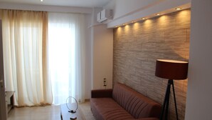 Una sala de estar moderna con un sofá marrón, un muro decorativo de madera y una lámpara de pie.