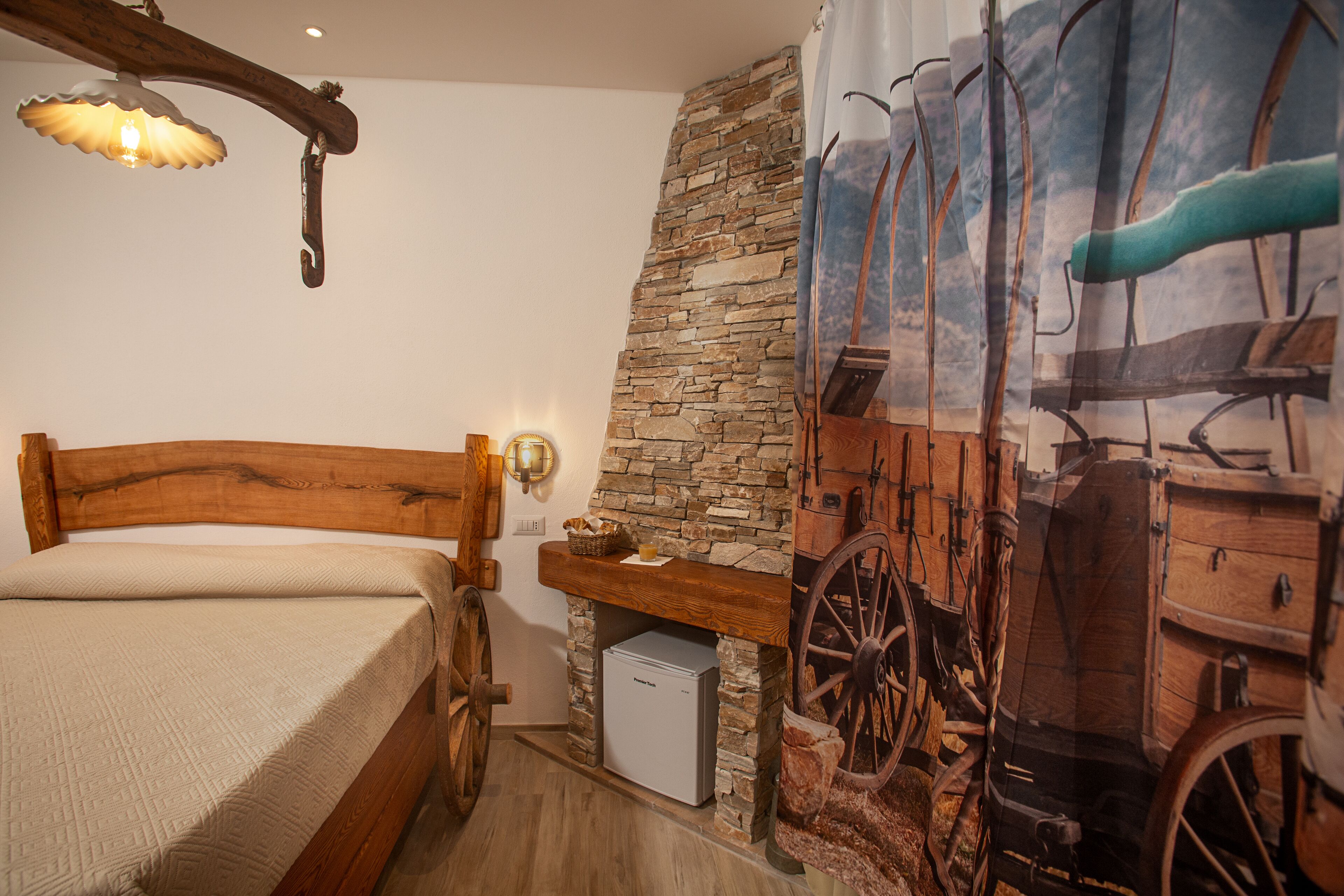 Un dormitorio con cama de madera, pared de piedra y un mural de un carruaje antiguo.