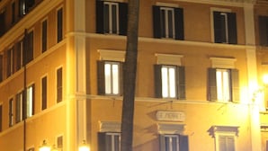 Ein Gebäude mit einem Schild, auf dem "E. PIERRET" steht, und einer Palme davor.