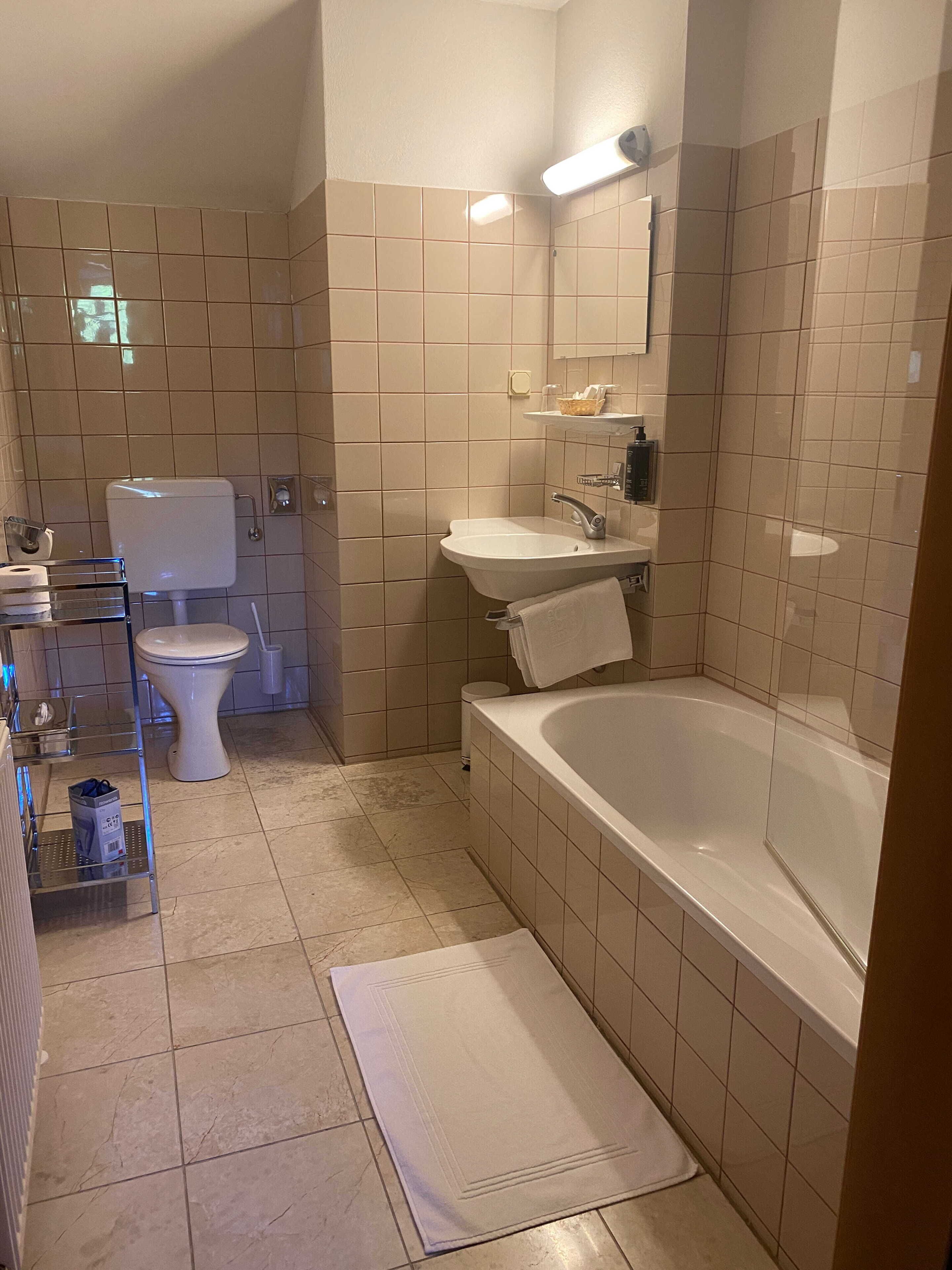 A bathroom with a toilet, sink, and bathtub.