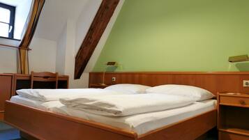 Een kamer met een houten bed, een bureau en een stoel.