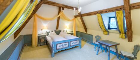 A bedroom with a bed, bedside tables, a desk, and chairs.
