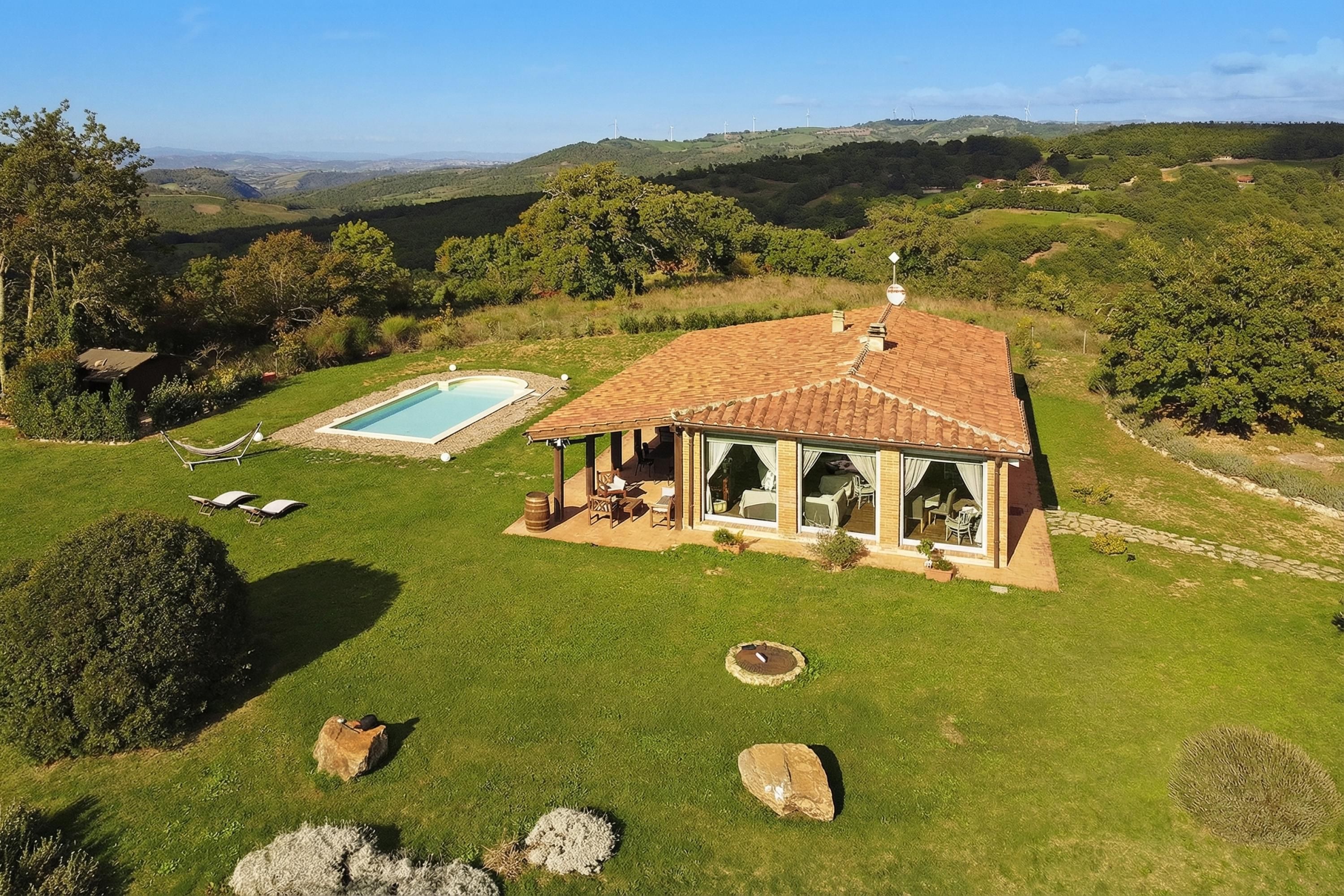 Une maison avec piscine, terrasse et vue panoramique.