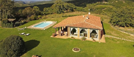 Une maison avec piscine, terrasse et vue panoramique.