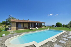 A swimming pool with lounge chairs, a stone building, and a clear sky. - Villa Borgiano (Scansano)