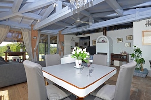 A covered patio area with a table and chairs, a potted plant, and a fireplace. - Villa Borgiano (Scansano)
