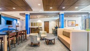 A modern lobby with a reception desk, seating area, and a large window. - Holiday Inn Express and Suites Asheboro by IHG (Asheboro)