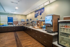 A breakfast area with a coffee machine, food display, and a refrigerator with dairy products. - Holiday Inn Express & Suites Dahlonega by IHG (Dahlonega)