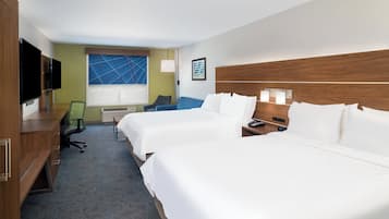A hotel room with two beds, a desk, a chair, a television, and a window with blinds.