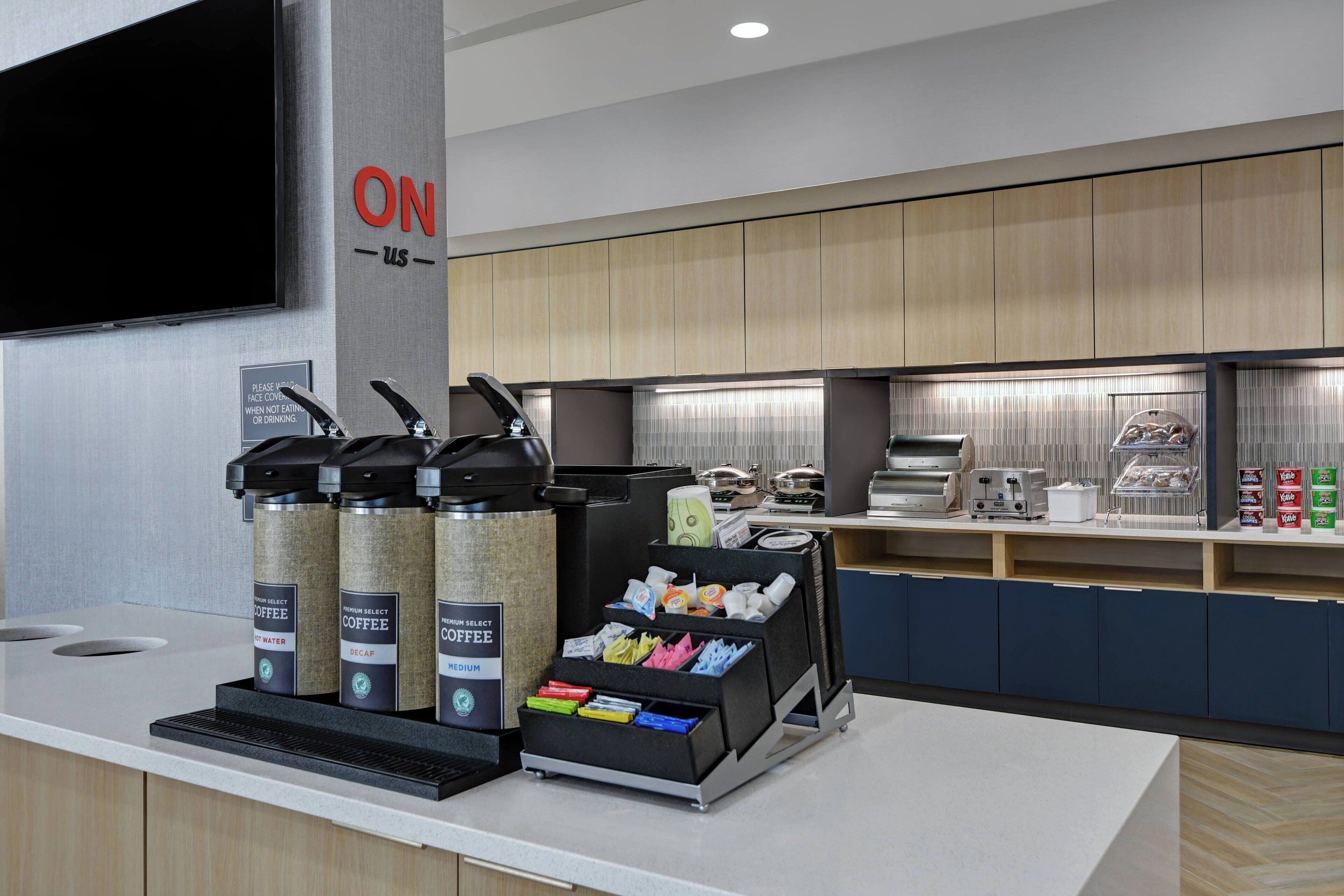 Una estación de café moderna con dispensadores de marca y una variedad de cápsulas de café.