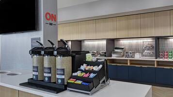 Una estación de café moderna con dispensadores de marca y una variedad de cápsulas de café.
