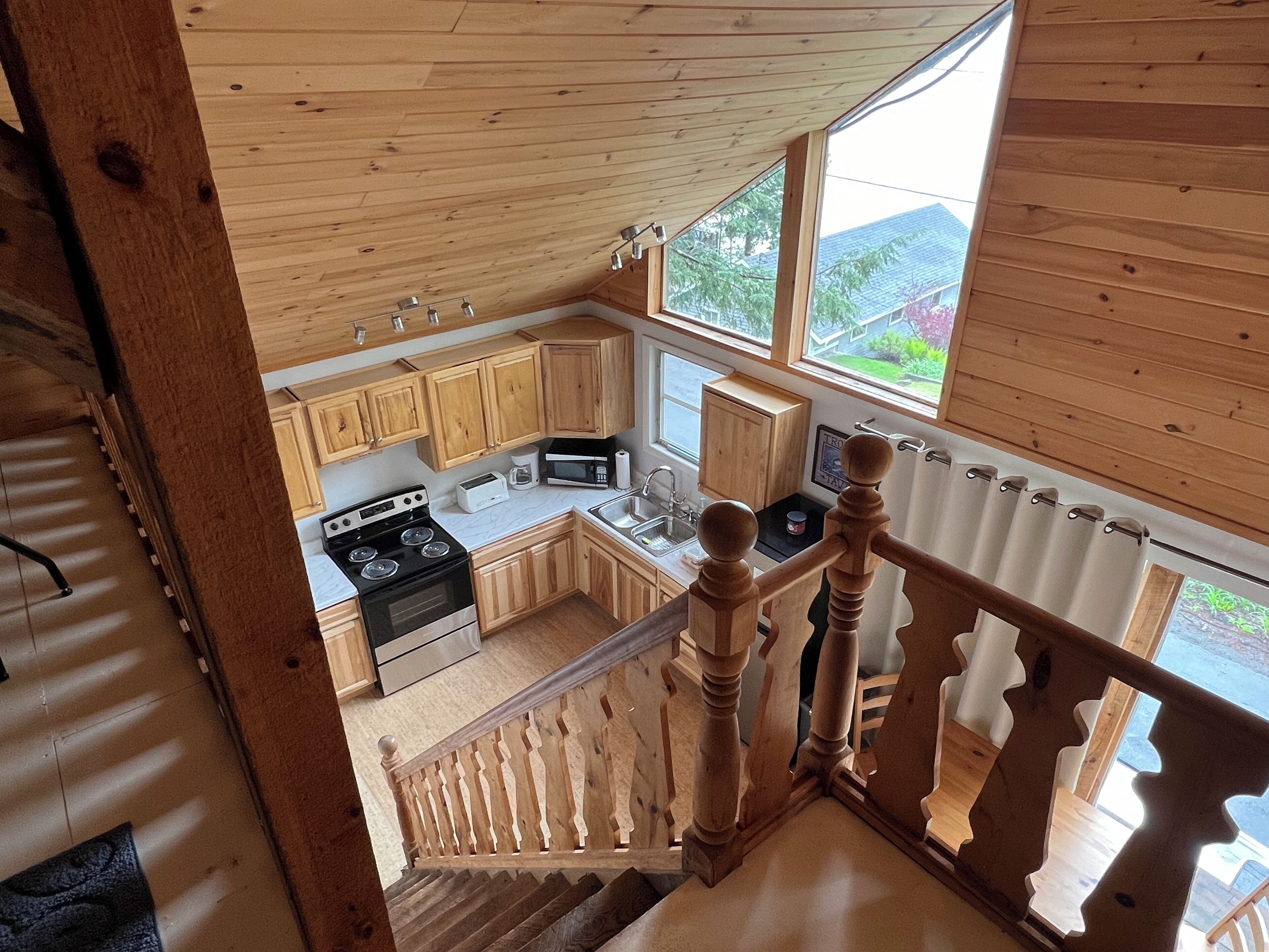 Une cuisine avec des meubles de rangement en bois, une cuisinière et un four à micro-ondes.