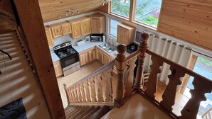 A kitchen with wooden cabinets, a stove, and a microwave.