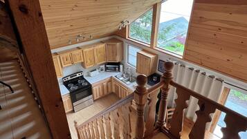Une cuisine avec des meubles de rangement en bois, une cuisinière et un four à micro-ondes.