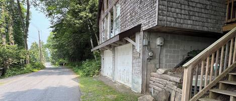 A rustic cabin with a wooden exterior, a front porch, and a staircase leading to the entrance.