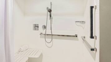 A modern bathroom with a walk-in shower, a toilet, and a towel rack.