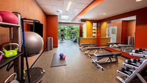 Une salle de sport équipée de matériel d’exercice, d’un tapis de yoga et d’une kettlebell.