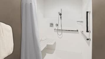 A modern bathroom with a shower, a towel rack, and a toilet.