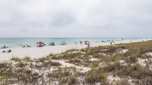 A beach with people, umbrellas, and tents.