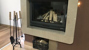 Una chimenea con una pantalla de televisión, un soporte con velas y fuego.