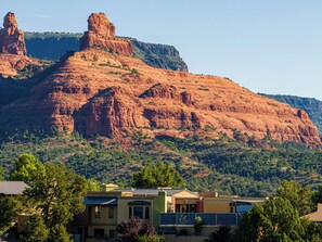 A residential area with houses in front of a large red rock formation.