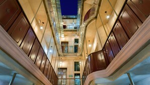 A multi-level interior with a central staircase, multiple floors, and a visible exit sign.