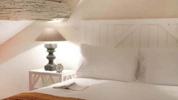 Une chambre à coucher avec un lit, une table de chevet, une lampe et une horloge.