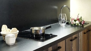 A kitchen with a black countertop, a stainless steel pan, a white mug, a basket of bread, and a vase with flowers. - Splendid duplex in Provence, in the middle of vineyards (Robion)
