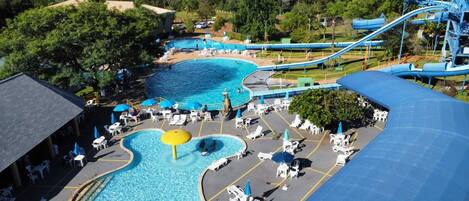 A water park with multiple pools, slides, and lounge areas.