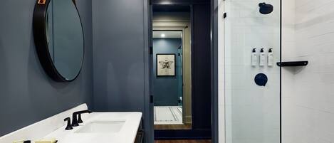 A modern bathroom with a double sink, a large mirror, and a glass shower enclosure.