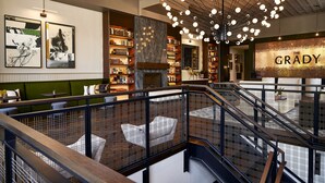 A multi-level interior with a staircase, bookshelves, and a prominent sign reading "THE GRADY". - The Grady (Louisville)