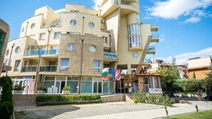 A multi-story building with a unique architectural design, featuring balconies and circular windows.