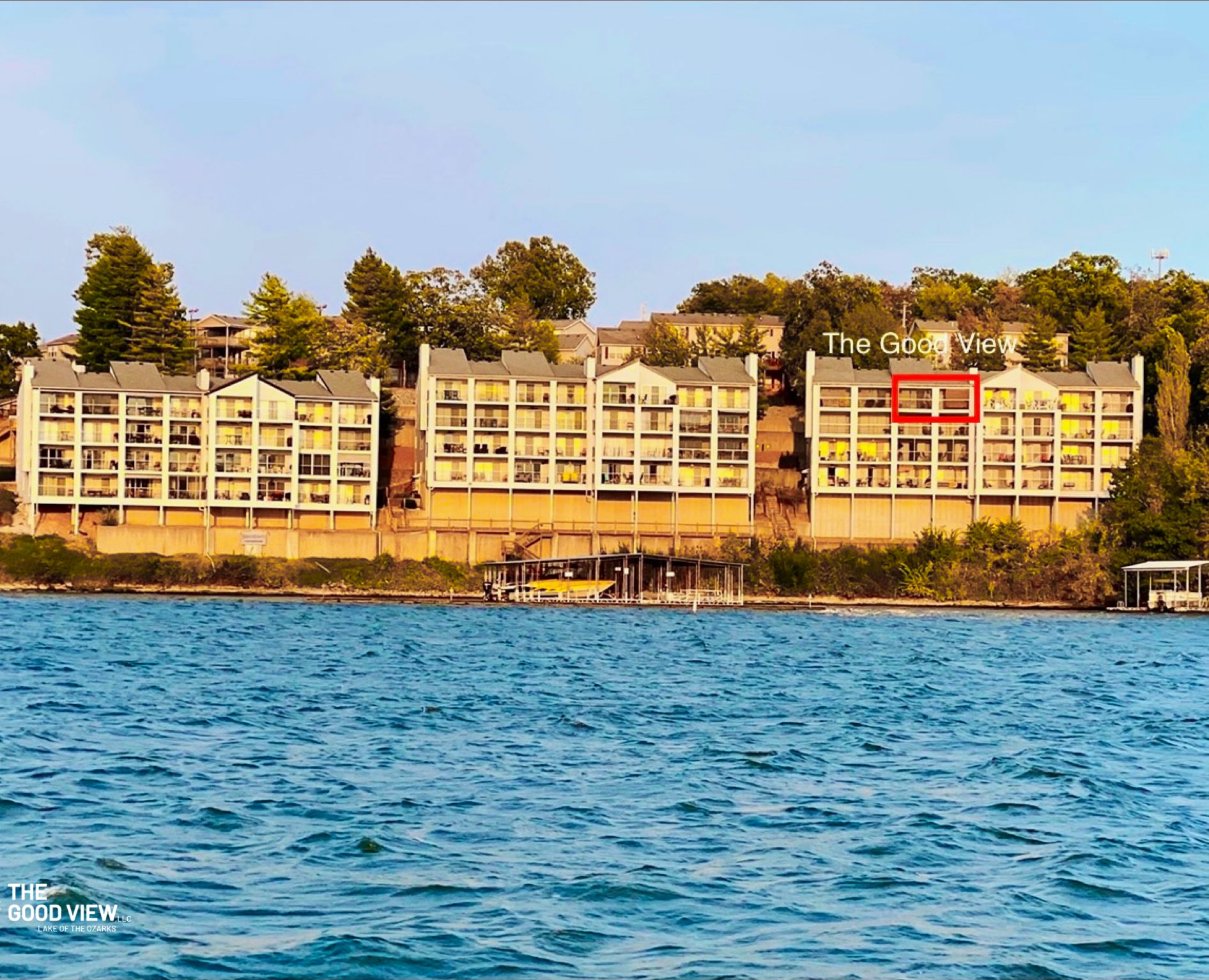 A waterfront hotel with multiple buildings, a dock, and a clear view of the water.