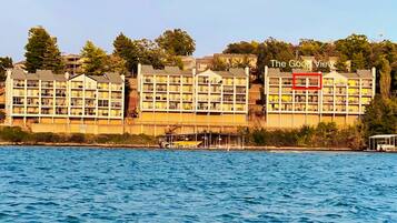 A waterfront hotel with multiple buildings, a dock, and a clear view of the water.