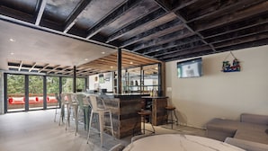 Eine moderne Küche mit Bar, großen Fenstern und Blick ins Freie.