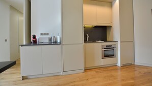 Eine kompakte Küche mit integrierten Geräten, einer Arbeitsplatte und Holzboden.