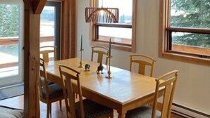 A wooden dining room with a high ceiling and large windows. - Post and Beam Country home on 40 Acres of land in the Blaeberry Valley, Golden. (Golden)