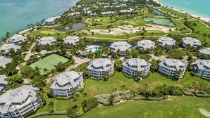 Een kustresort met diverse villaoppervlaktes aan het strand, een golfbaan en een zwembad.