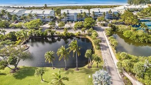A resort with multiple buildings, a central pond, and a view of the ocean. - Beach Villas (Captiva)