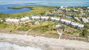 An aerial view of a coastal resort with multiple buildings, a beach, and a water body. - Beach Villas (Captiva)