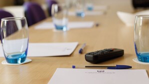 A conference table with a remote control, a pen, and a document titled "Carlton Manor." - The Carlton Manor Hotel (Lowestoft)